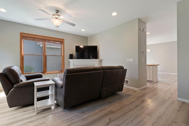 living room with ceiling fan and light hardwood / wood-style flooring