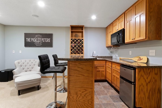 kitchen with a breakfast bar, kitchen peninsula, and sink