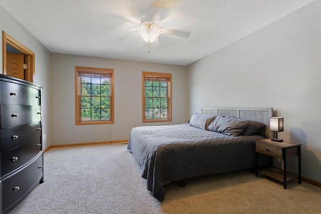 carpeted bedroom featuring ceiling fan and a textured ceiling