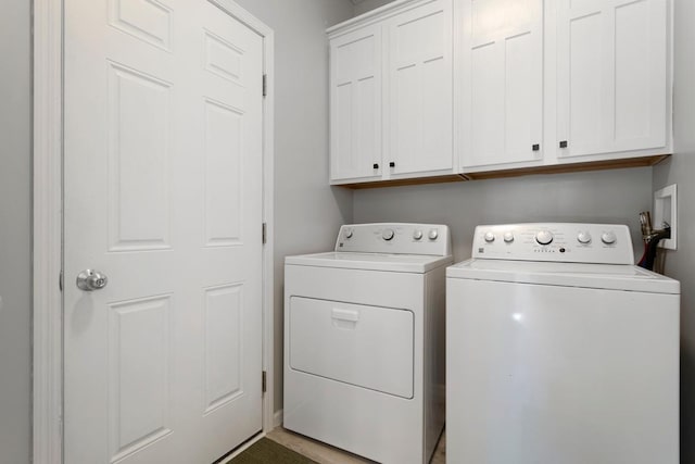 clothes washing area with cabinets and independent washer and dryer