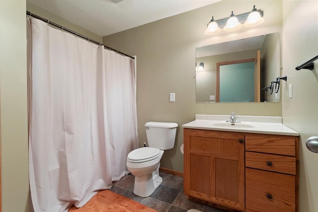 bathroom with a textured ceiling, vanity, and toilet