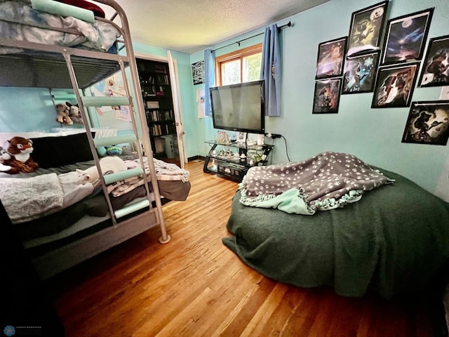 bedroom with hardwood / wood-style flooring and a textured ceiling