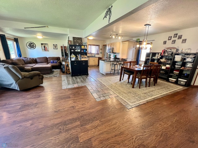 living room with hardwood / wood-style floors, a notable chandelier, and a textured ceiling