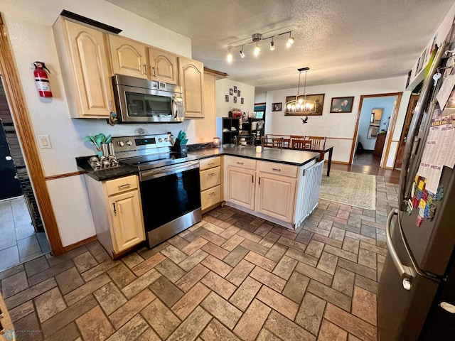 kitchen featuring appliances with stainless steel finishes, decorative light fixtures, light brown cabinetry, and kitchen peninsula