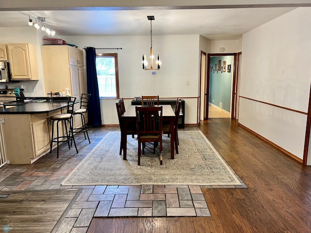 dining area featuring dark hardwood / wood-style flooring, a chandelier, and a textured ceiling