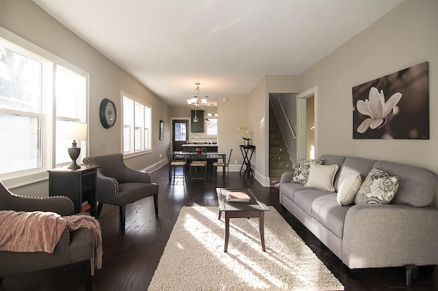 living room featuring dark hardwood / wood-style floors and an inviting chandelier