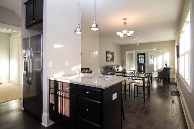 kitchen featuring pendant lighting, dark hardwood / wood-style flooring, stainless steel fridge with ice dispenser, and an inviting chandelier