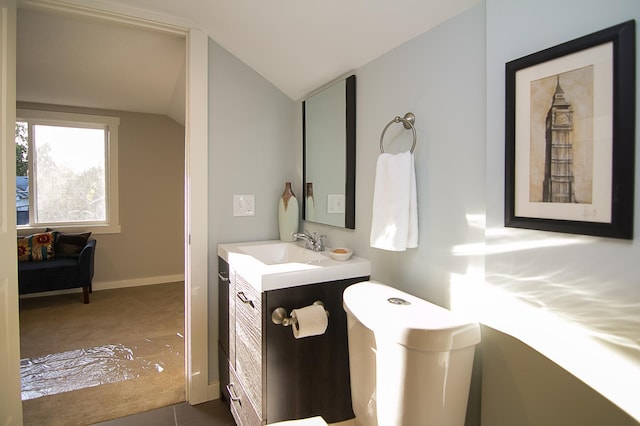 bathroom featuring tile patterned floors, vanity, and vaulted ceiling