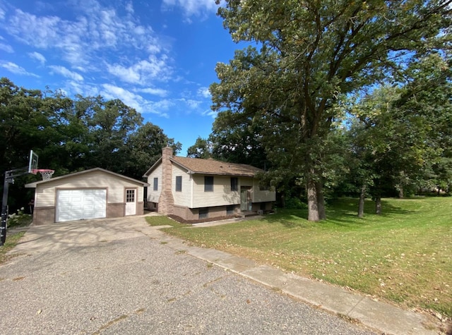 view of front of house featuring a garage, an outbuilding, and a front yard