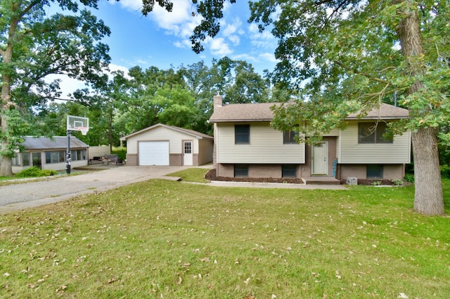 split foyer home featuring a front yard, a garage, and an outdoor structure