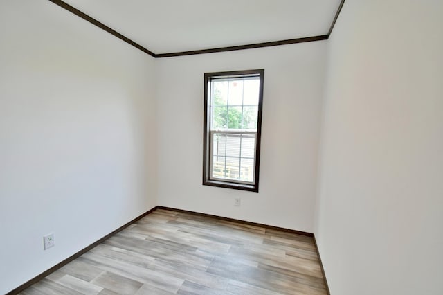 empty room with light wood-type flooring and ornamental molding