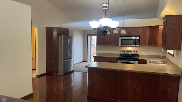 kitchen featuring kitchen peninsula, stainless steel appliances, sink, pendant lighting, and a chandelier