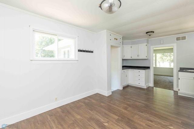 kitchen with dark hardwood / wood-style flooring, white cabinetry, and ornamental molding