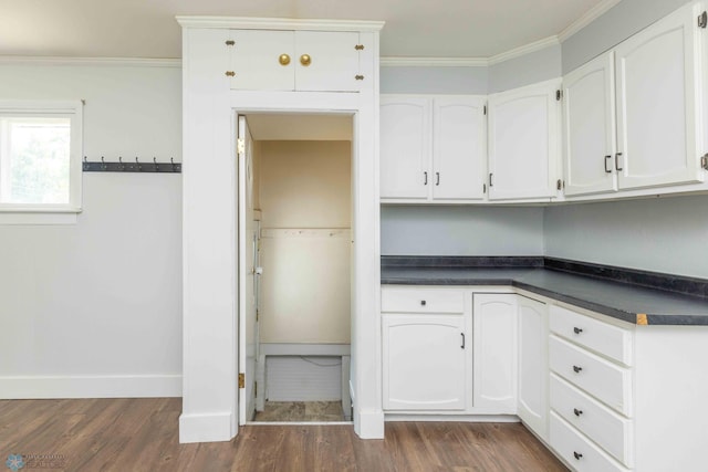 kitchen featuring crown molding, dark hardwood / wood-style flooring, and white cabinets