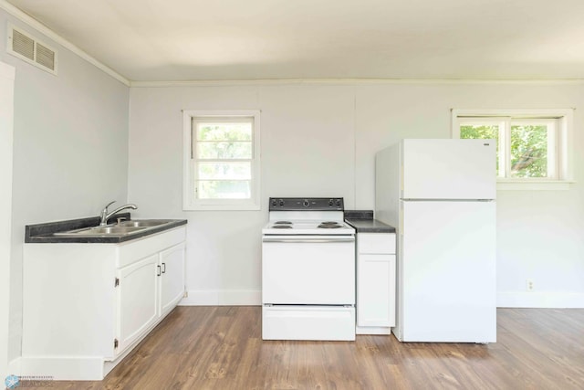 kitchen featuring white appliances, sink, hardwood / wood-style flooring, a wealth of natural light, and white cabinetry