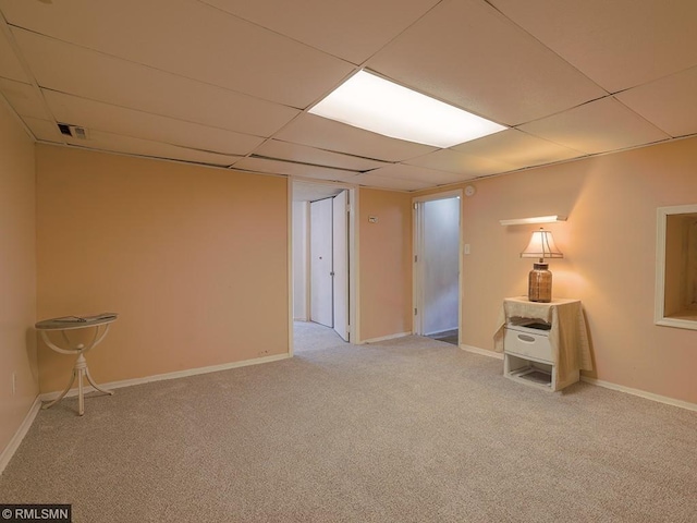 unfurnished room with a paneled ceiling and light carpet