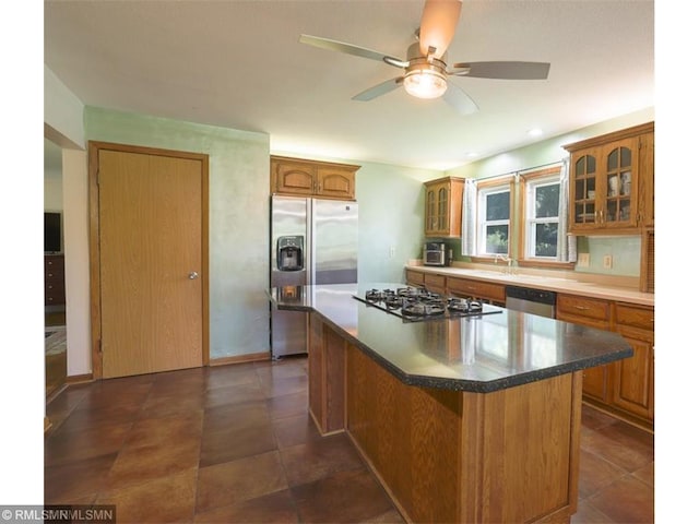 kitchen with appliances with stainless steel finishes, a center island, and ceiling fan