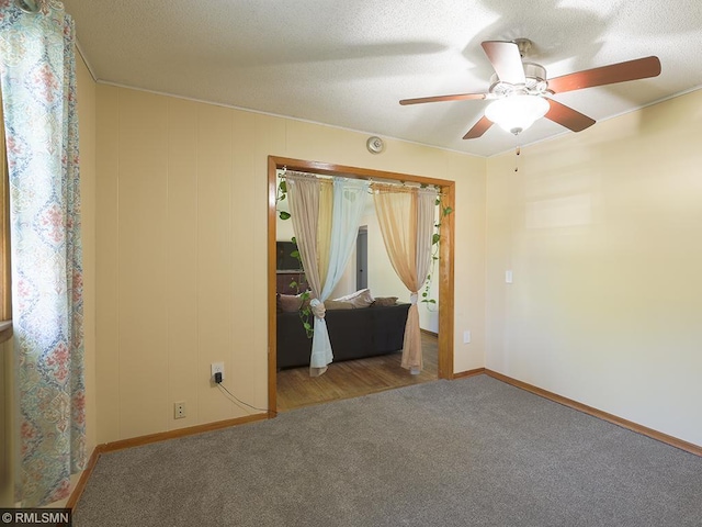 spare room featuring carpet flooring, ceiling fan, and a textured ceiling