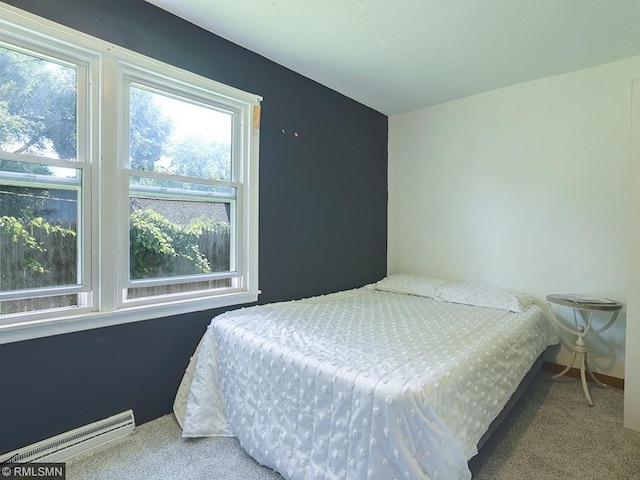 bedroom with baseboard heating and carpet floors