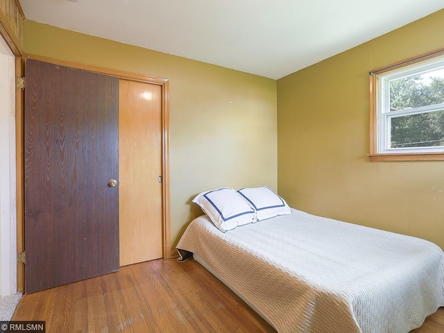 bedroom featuring hardwood / wood-style floors and a closet