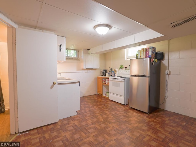 kitchen featuring stainless steel refrigerator, sink, dark parquet floors, and white electric stove