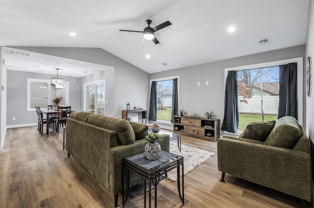 living room with ceiling fan, light hardwood / wood-style flooring, and lofted ceiling