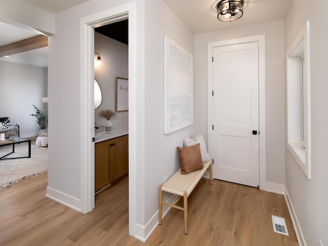 interior space with beamed ceiling and light hardwood / wood-style floors