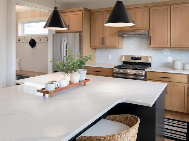 kitchen with backsplash, light stone counters, decorative light fixtures, and appliances with stainless steel finishes