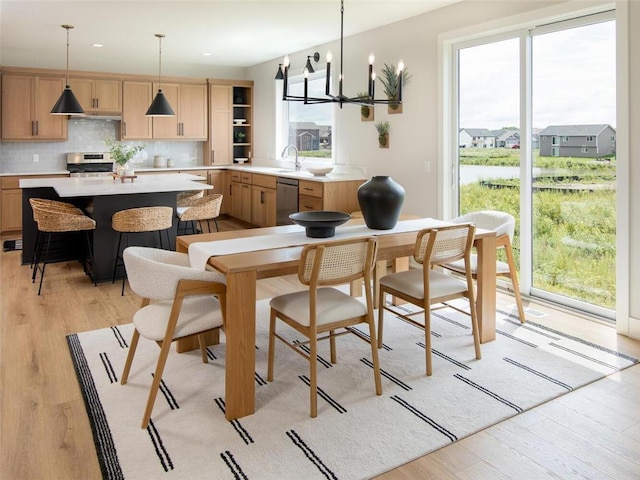 kitchen featuring decorative light fixtures, stove, light hardwood / wood-style flooring, and an inviting chandelier