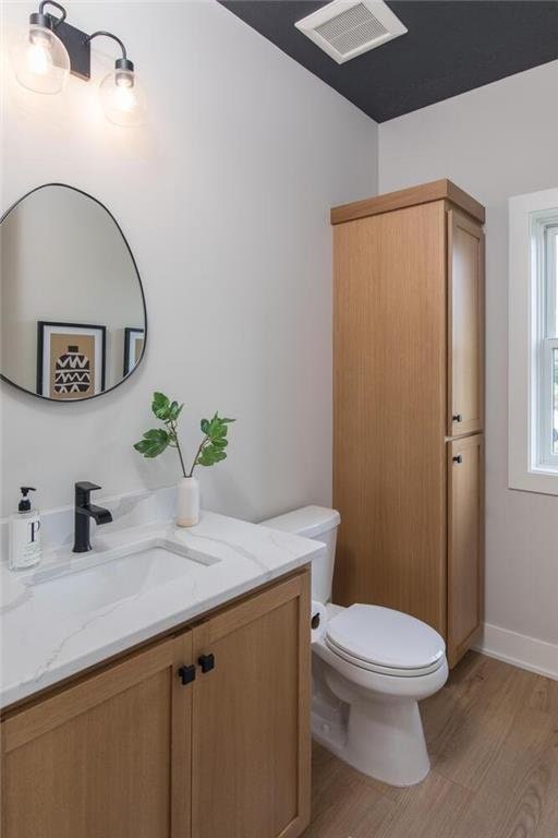 bathroom featuring hardwood / wood-style flooring, vanity, and toilet