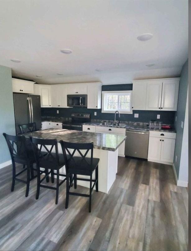 kitchen with white cabinets, a kitchen bar, and stainless steel appliances