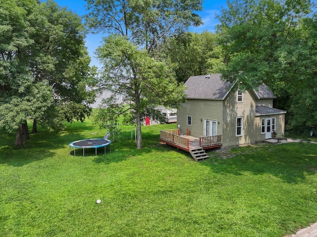 view of yard with a deck and a trampoline