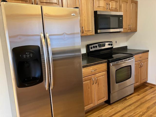 kitchen with appliances with stainless steel finishes and light hardwood / wood-style floors