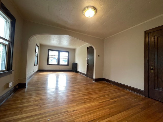 unfurnished room featuring hardwood / wood-style floors and crown molding