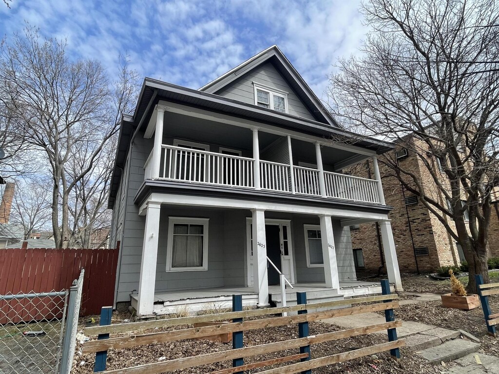 view of front facade with covered porch and a balcony