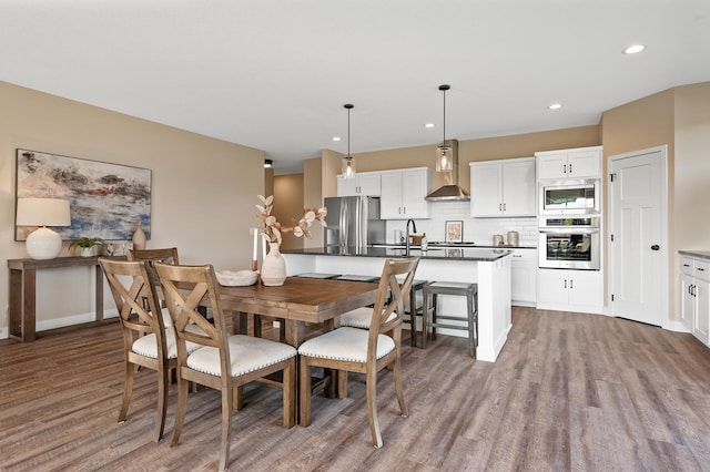 dining space with hardwood / wood-style flooring and sink