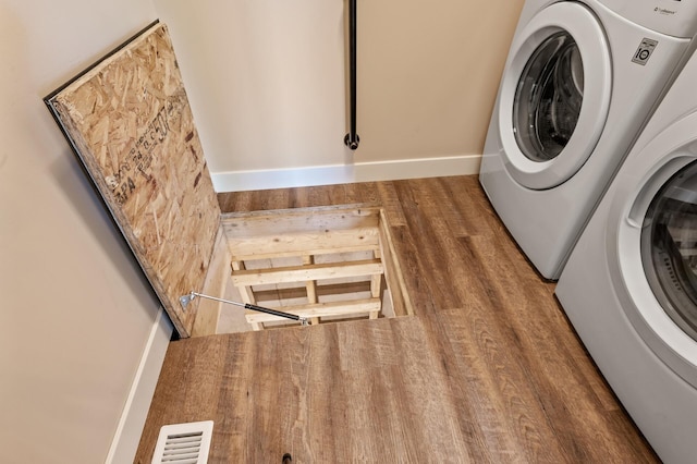 laundry room with wood-type flooring and washer / clothes dryer