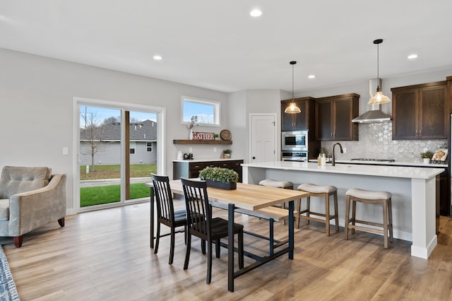 dining space with sink and light wood-type flooring