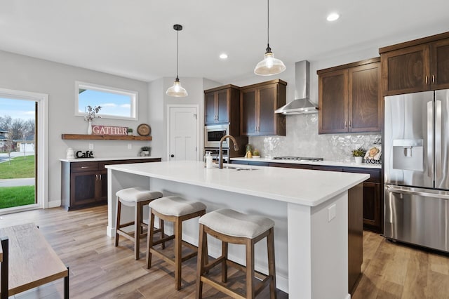 1242 Willowbrook Cir, Delano, MN 55328 - kitchen featuring appliances with stainless steel finishes, wall chimney range hood, tasteful backsplash, dark brown cabinets, and recessed lighting
