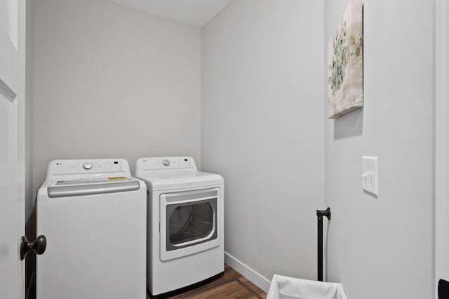 laundry room featuring washing machine and dryer and dark hardwood / wood-style flooring