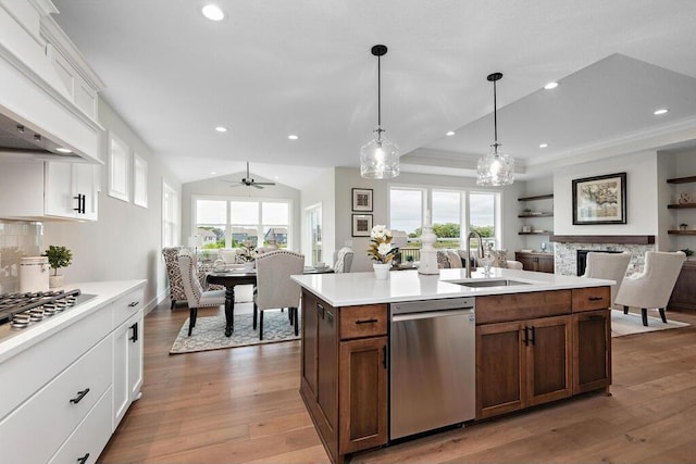 kitchen with pendant lighting, premium range hood, sink, appliances with stainless steel finishes, and white cabinetry