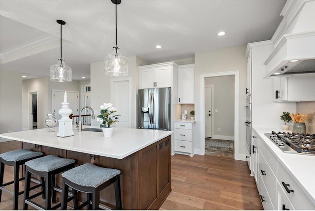 kitchen featuring a large island, sink, light hardwood / wood-style floors, appliances with stainless steel finishes, and custom exhaust hood