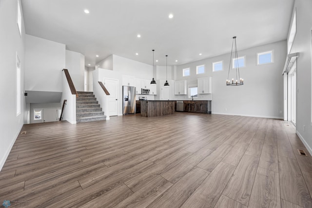 unfurnished living room featuring a towering ceiling and sink