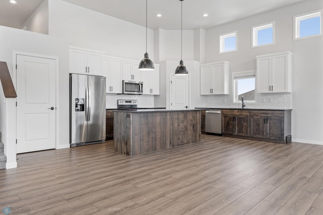 kitchen with pendant lighting, a center island, white cabinets, and appliances with stainless steel finishes