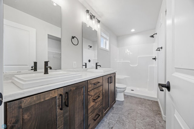 bathroom featuring a shower, vanity, and toilet