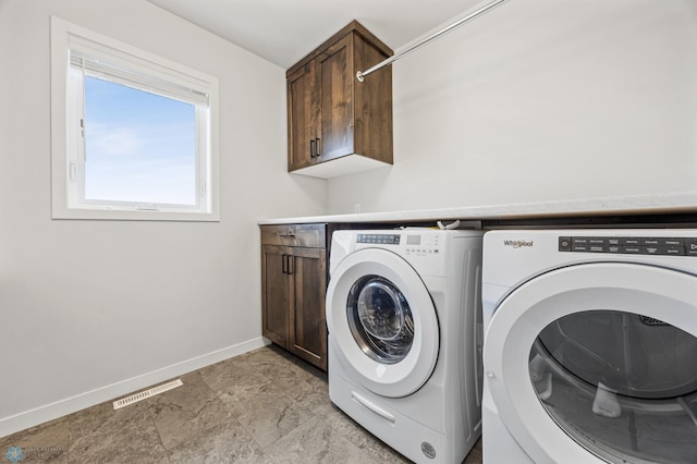 washroom featuring cabinets and independent washer and dryer