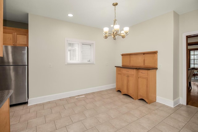 unfurnished dining area with a notable chandelier