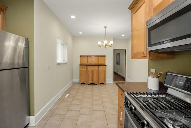 kitchen featuring pendant lighting, light tile patterned floors, appliances with stainless steel finishes, a notable chandelier, and dark stone counters