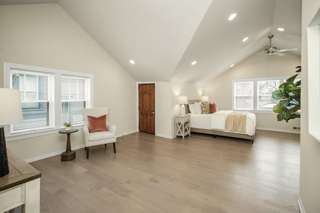 bedroom featuring multiple windows, vaulted ceiling, ceiling fan, and light hardwood / wood-style floors