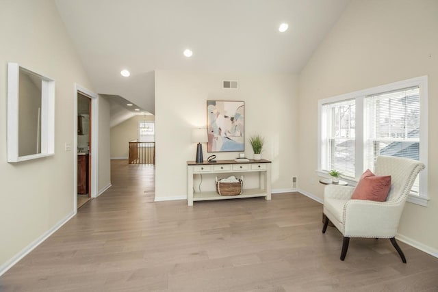 sitting room with high vaulted ceiling and light wood-type flooring